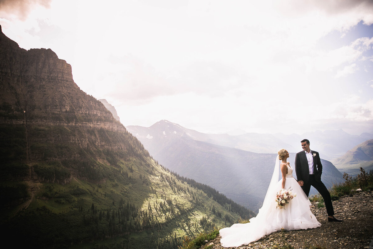 bride and groom standing by mountain