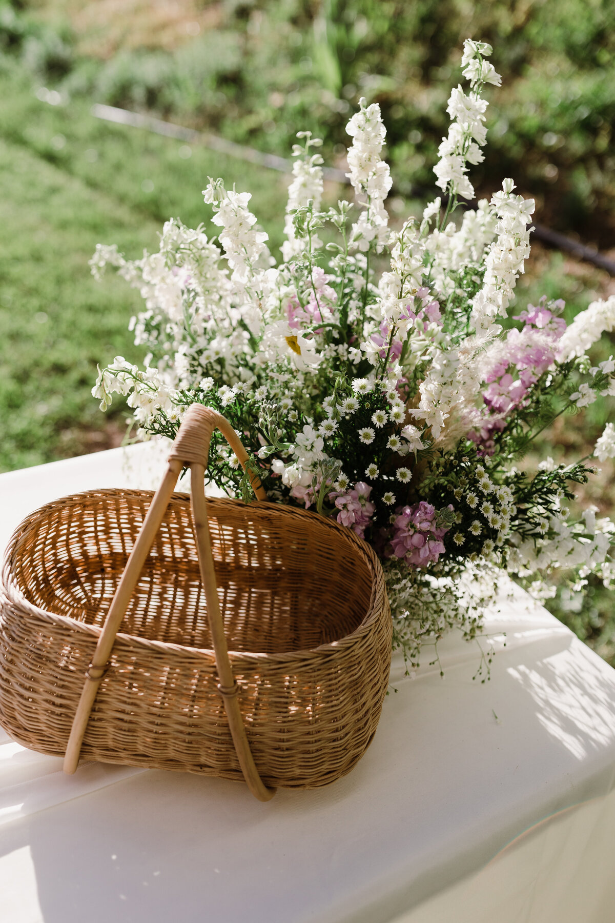 Wicker basket and white and purple florals at Dallenbach Ranch Colorado Wedding
