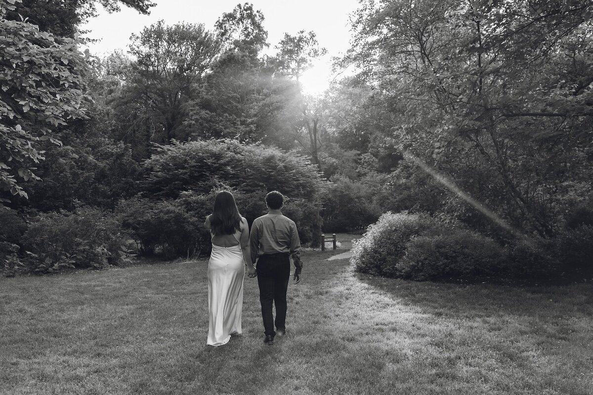 Black-and-white photo of couple walking together in the gardens.