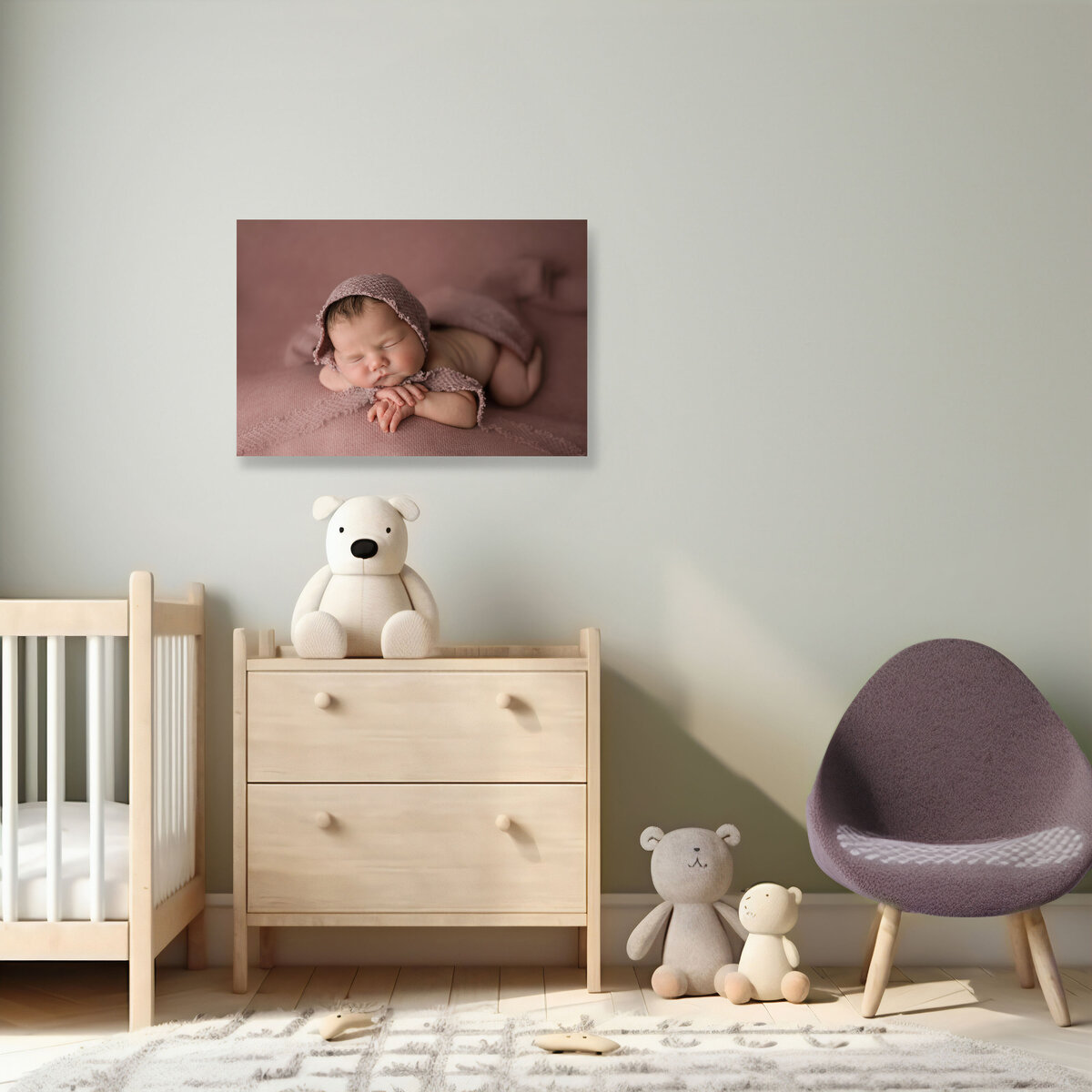 A newborn portrait hanging above a dresser in a nursery
