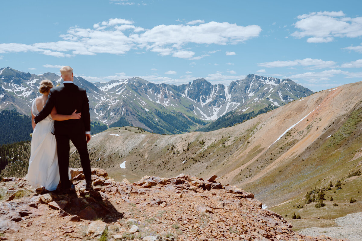 Couple looks out over Colorado mountain range
