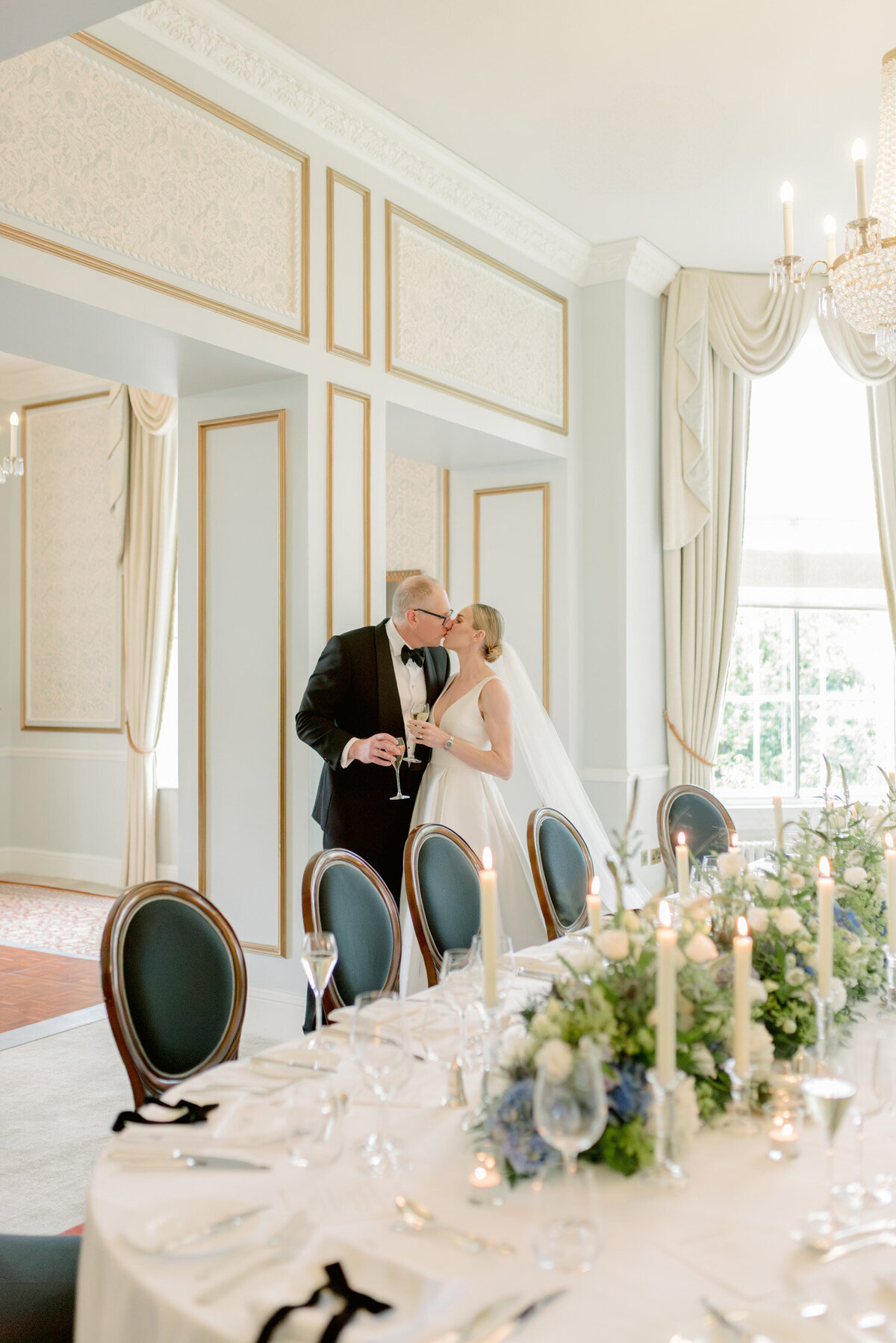 Bride and Groom kiss in the interior of Gleneagles Hotel on their wedding day. Image by award winning luxury wedding photographer Scotland, Jill Cherry Porter.