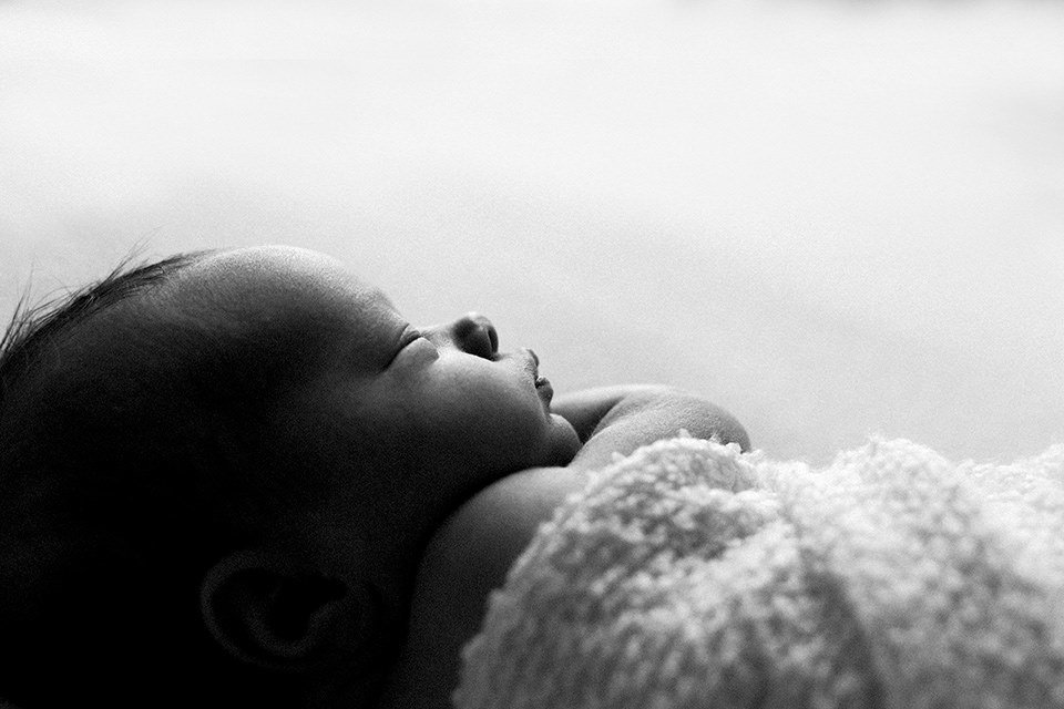 Newborn baby's profile on a white backdrop