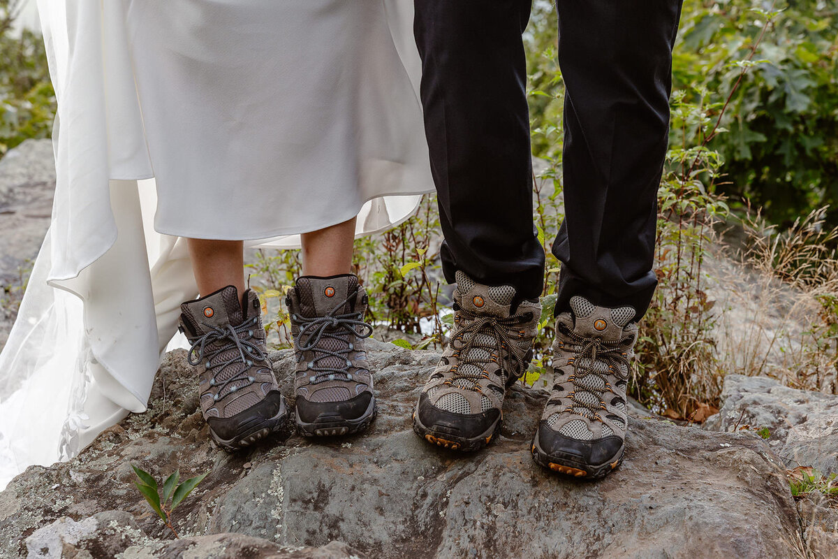 A couple's feet with hiking boots on them.