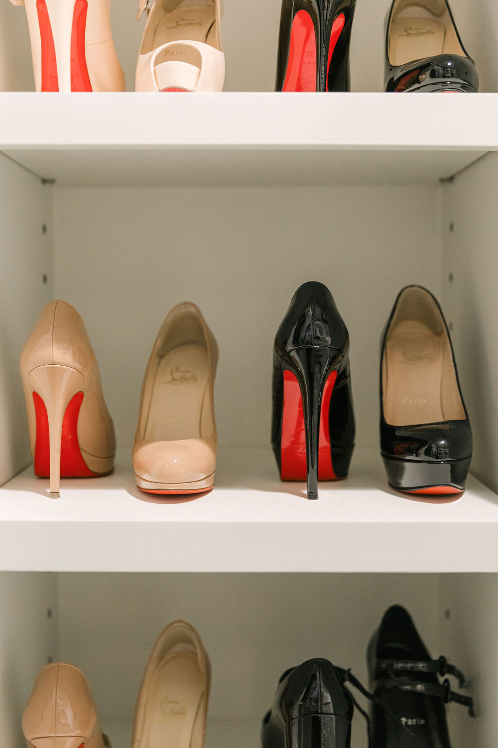 Christian Louboutin red sole high heels organized in closet