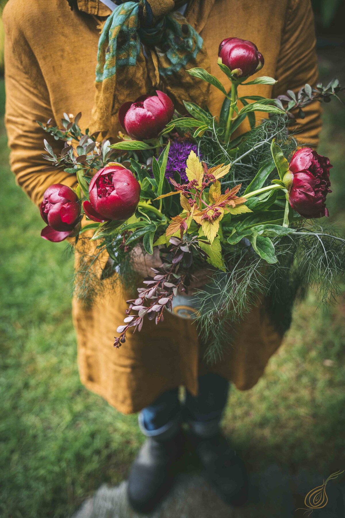 A woman gracefully holds a vibrant bouquet of flowers, showcasing her joy and appreciation for nature's beauty.