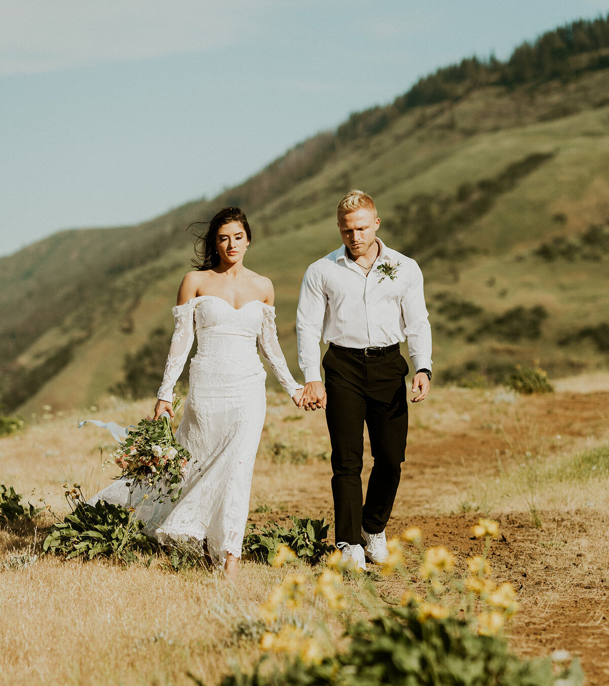 the-bride-and-groom-are-standing-in-the-field-and-hilding-hands
