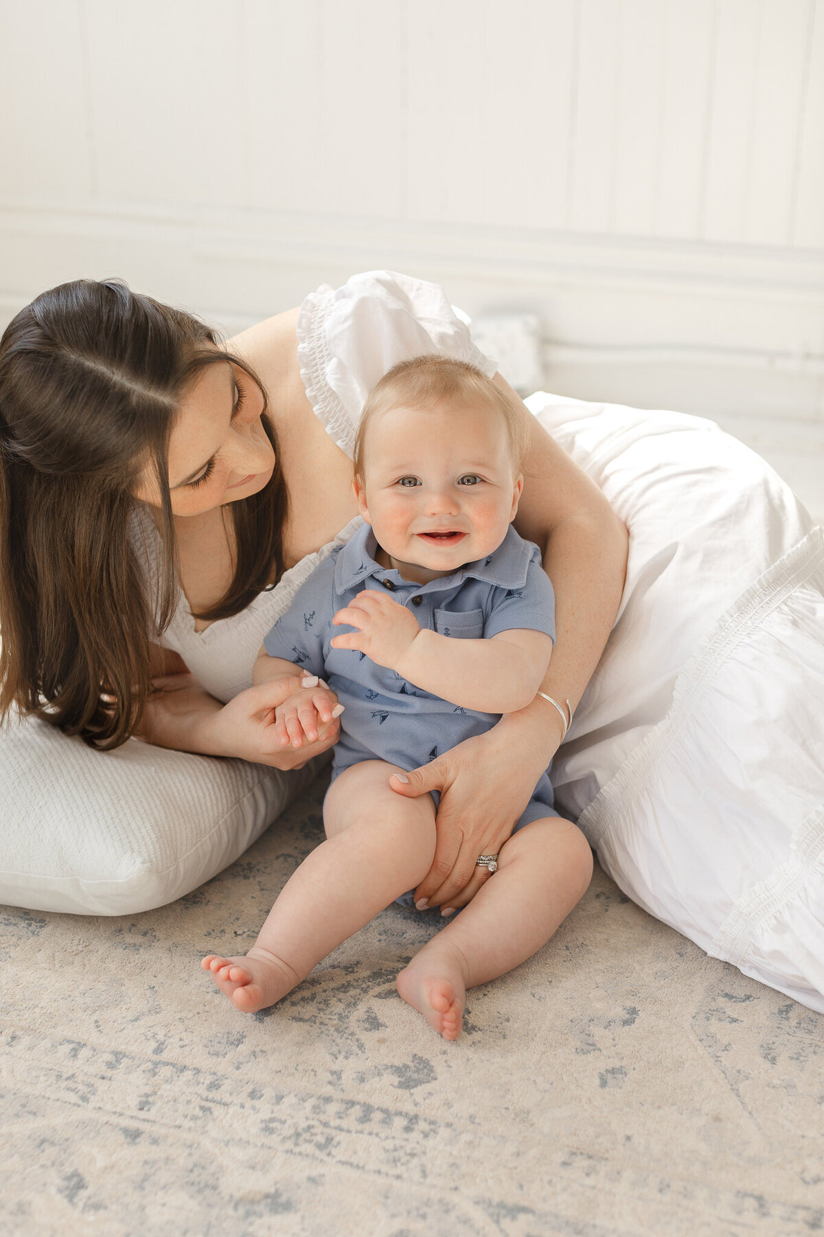 mom lays next to baby boy during boston photoshoot