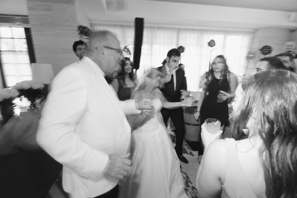 Bride dancing with guests under warm evening lighting

