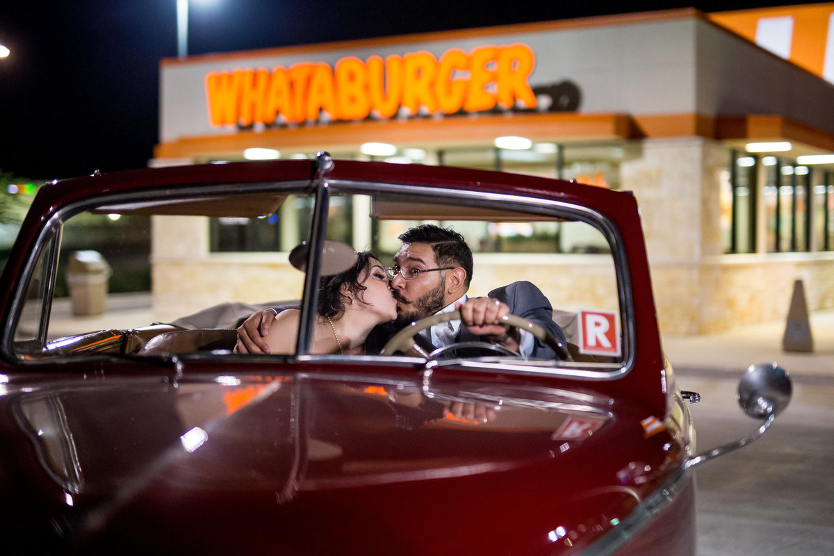 Bride and groom kissing in classic car after wedding in front of Whataburger. San Antonio Whataburger wedding.