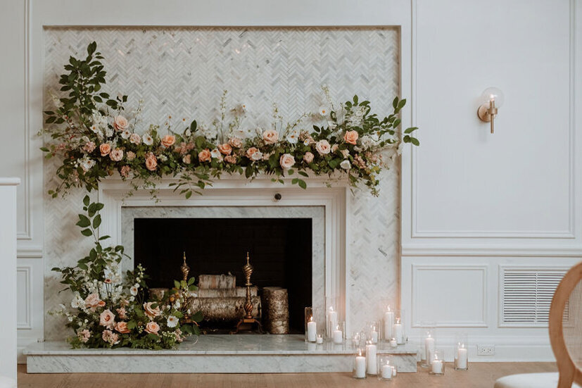 An airy meadow of flowers on a fireplace decorate a wedding ceremony at the Atwater Club.