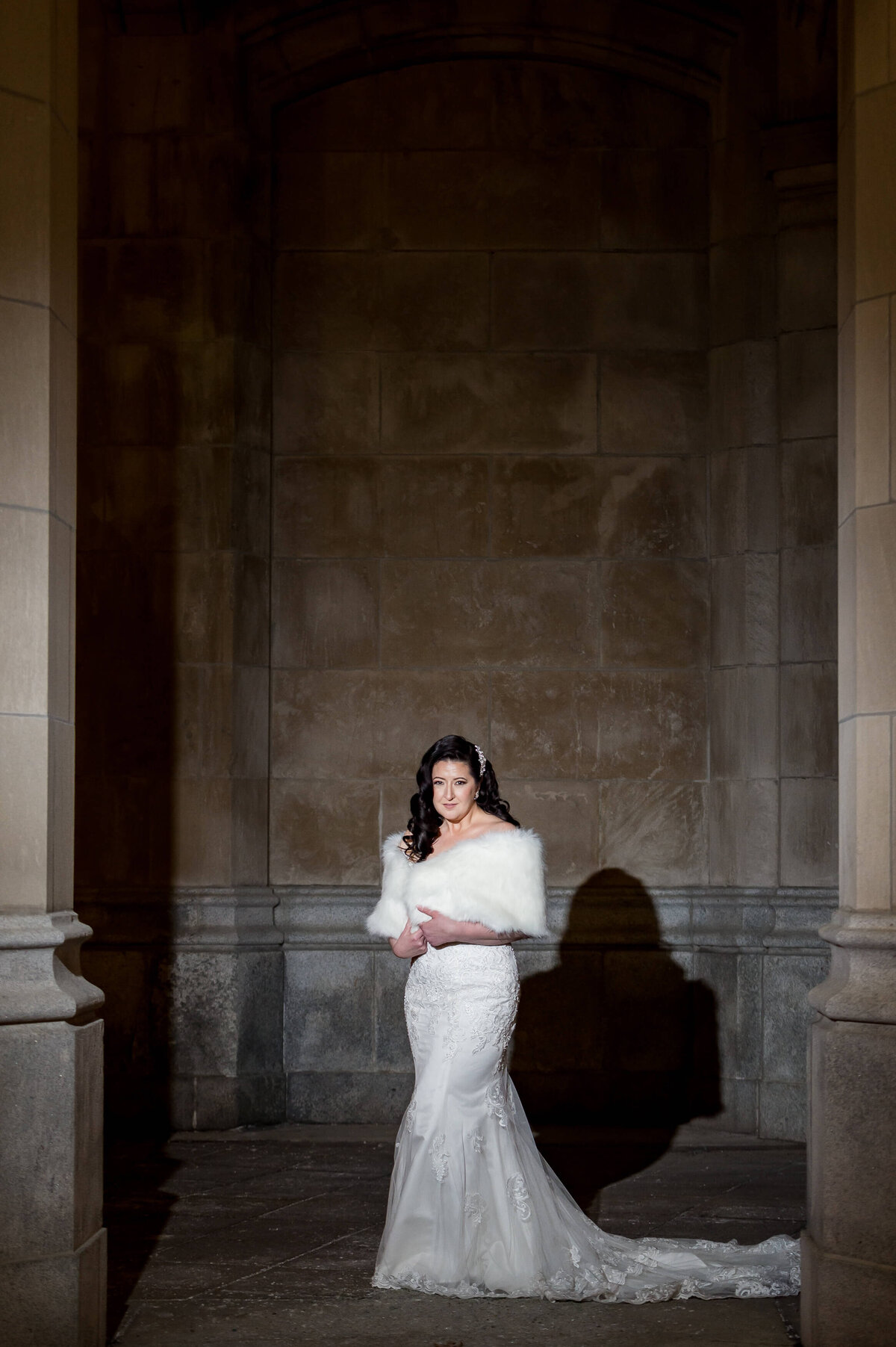 a full length portrait of a bride wearing a stole taken outside the Chateau Laurier hotel.  Captured by Ottawa wedding photographer JEMMAN Photography