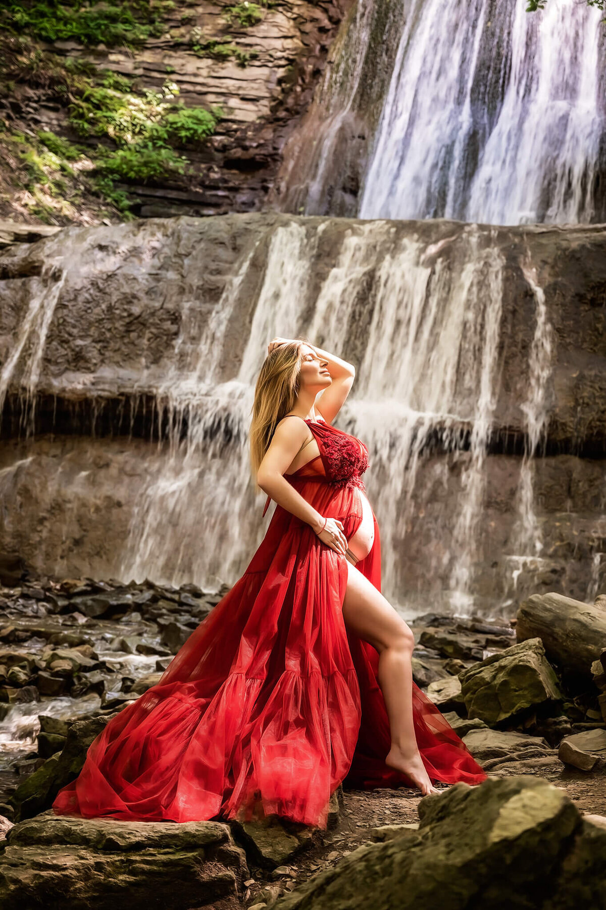 Stunning mom to be at a waterfall pregnancy  photo session.