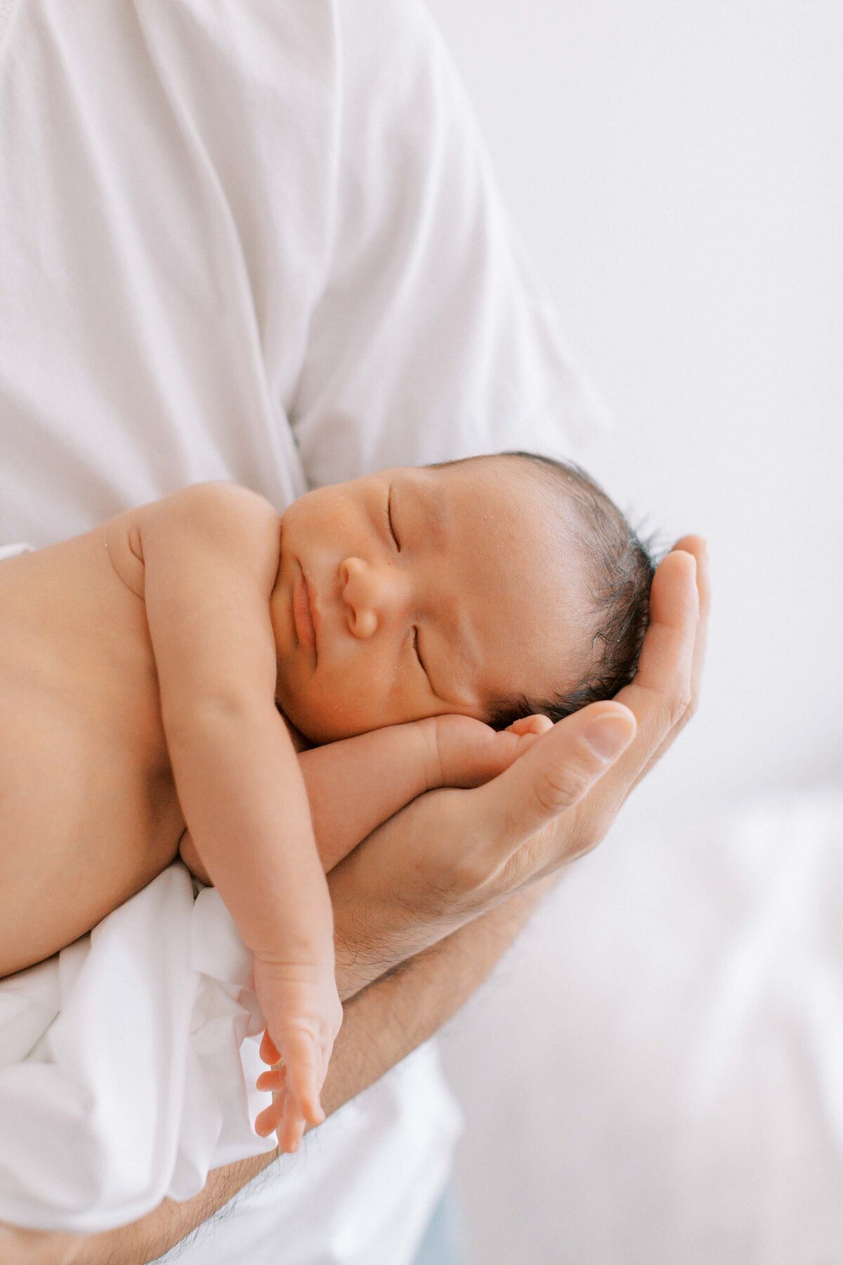 newborn son in dad's hands