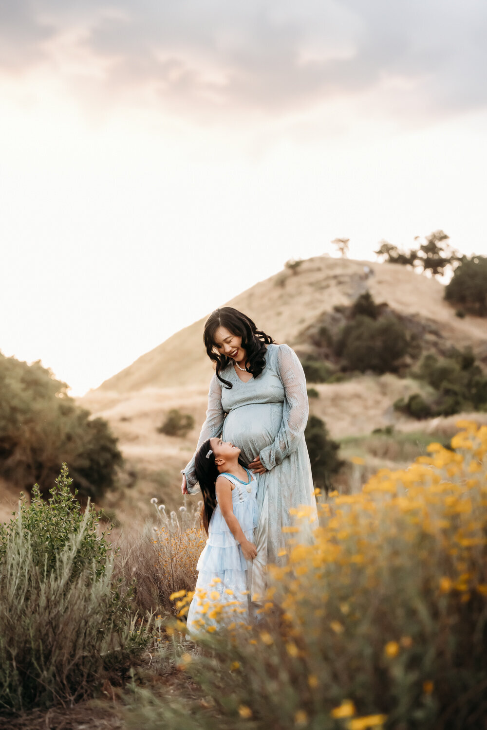 little girl hugs her mamas belly