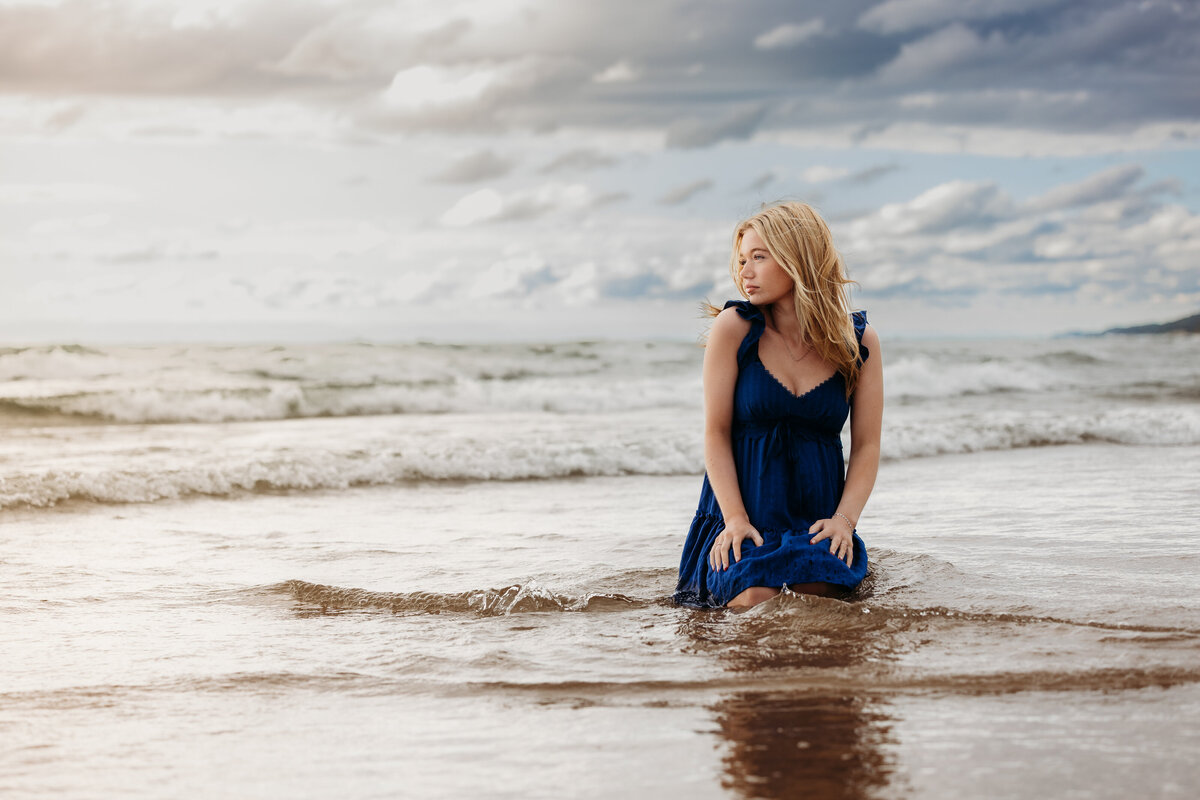 senior-girl-kneeling-on-beach