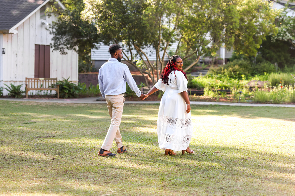 black couple walking holding hands at Columbus Georgia Botanical Garden by Columbus Georgia wedding photographer Amanda Richardson Photography