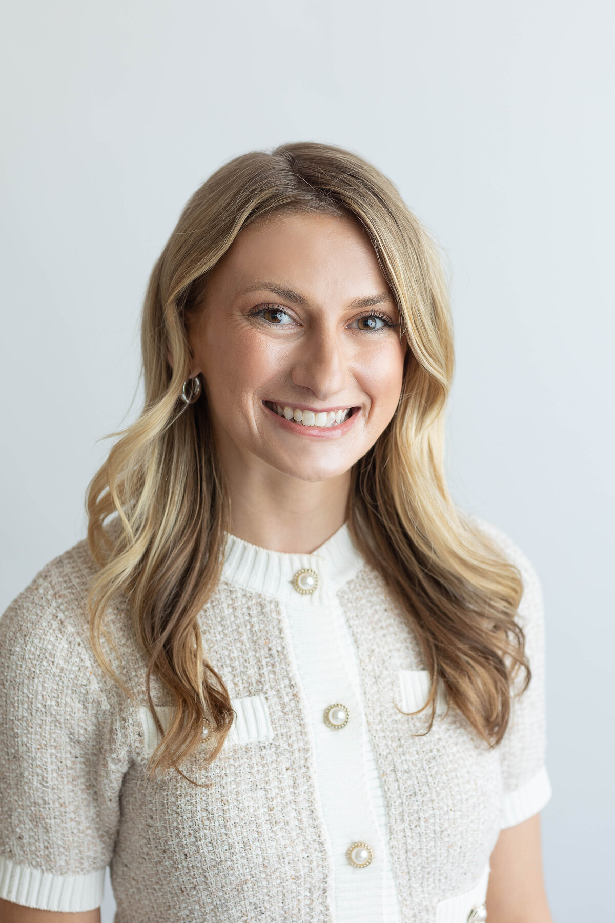 Headshot of a smiling woman in a pale sweater