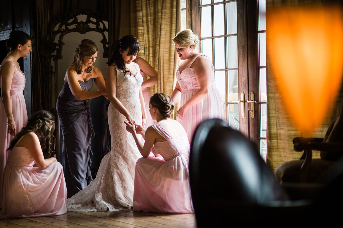 A bride is surrounded by bridesmaids and many wedding details.