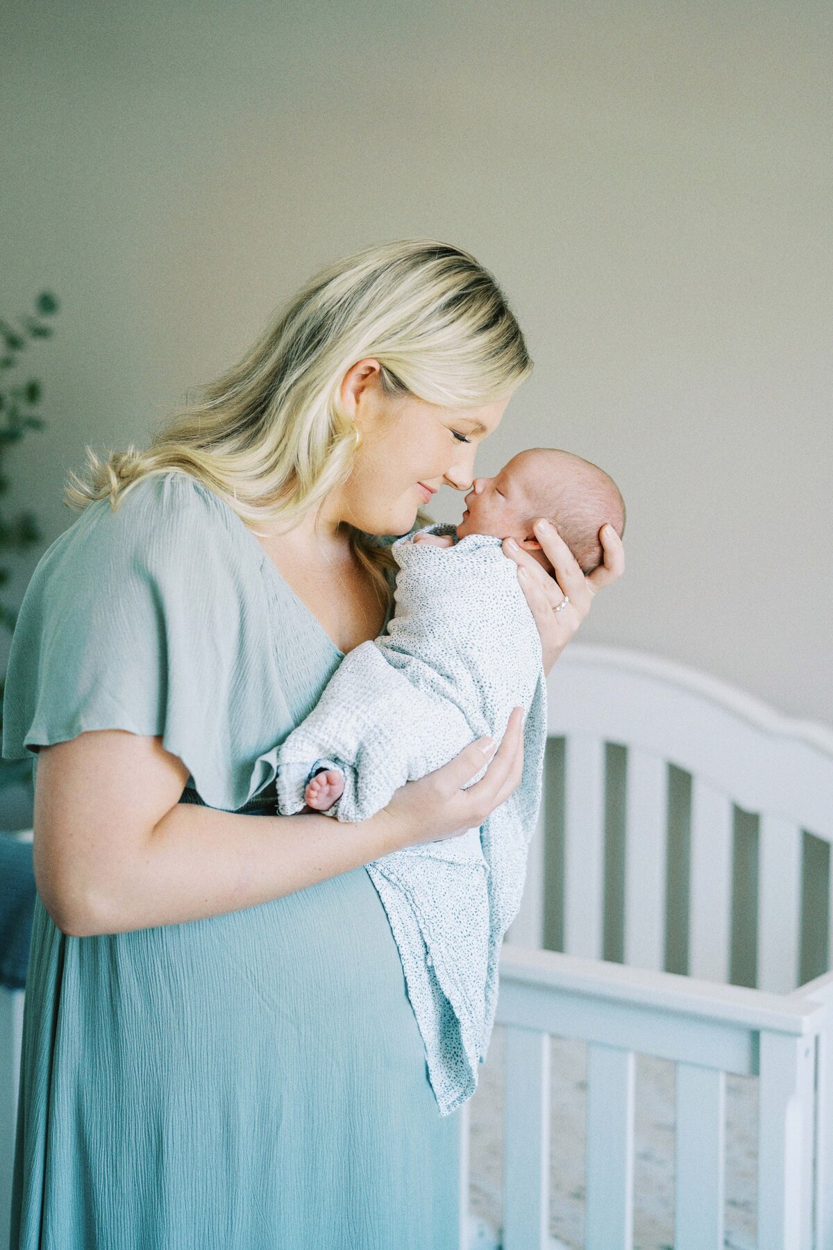 mom touching noses with newborn baby