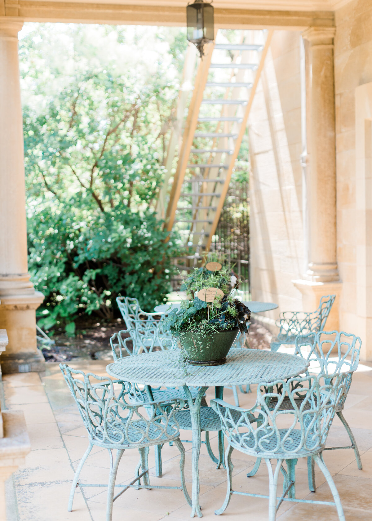 A sunny patio has a blue metal garden furniture set.