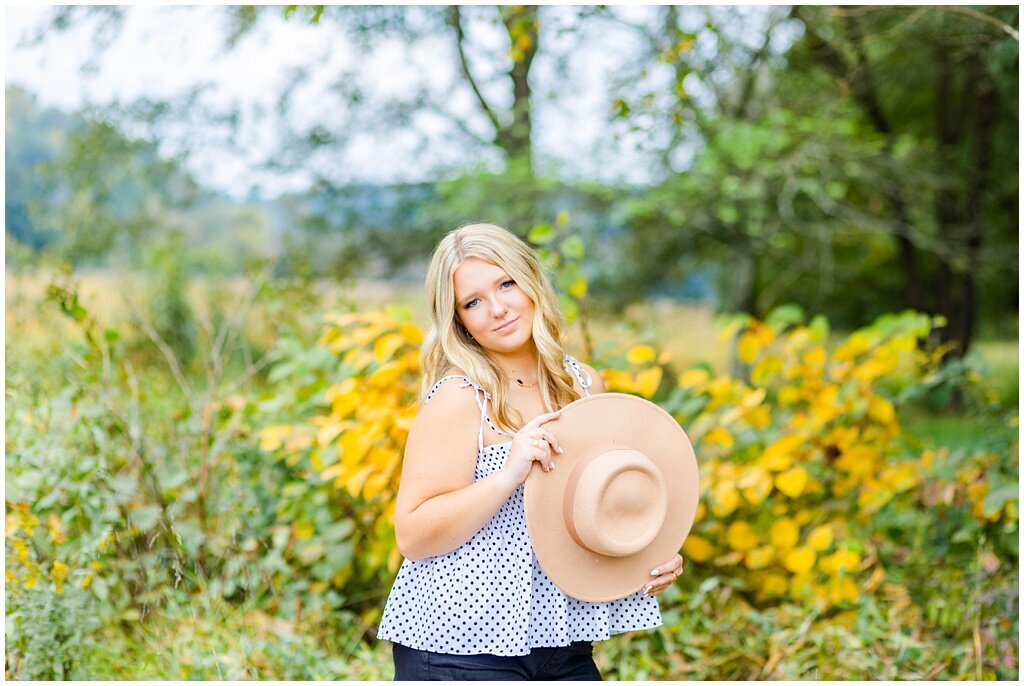 senior girl holding hat