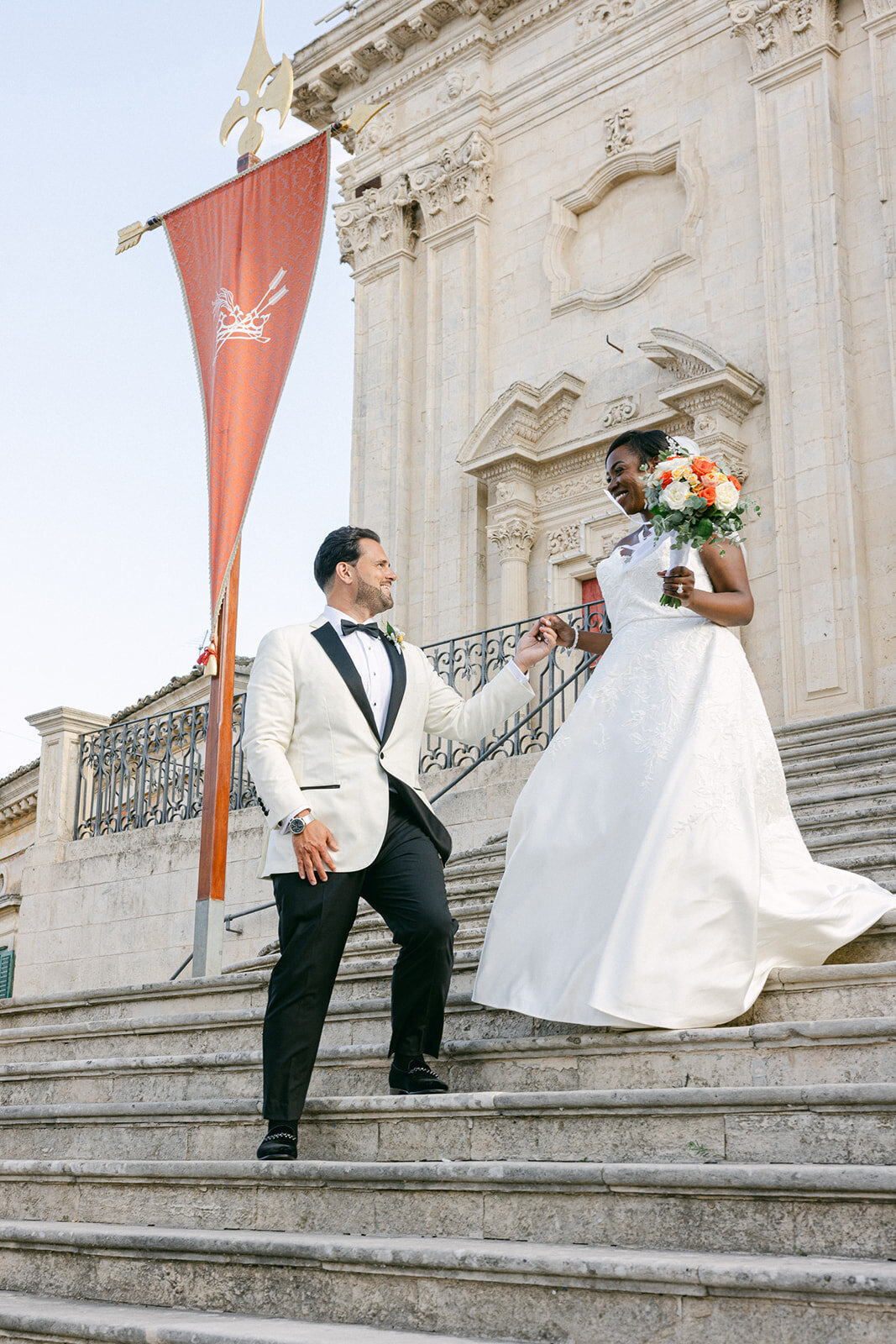 a man helping his bride down steps
