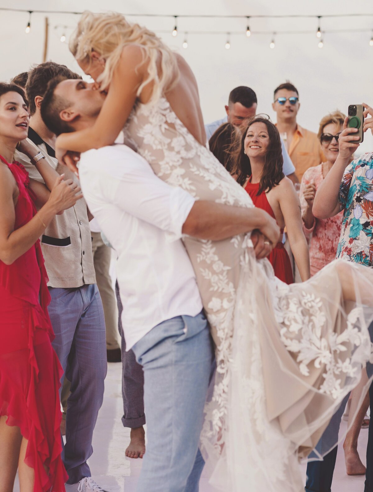 Groom lifting bride on dance floor at wedding in Cancun