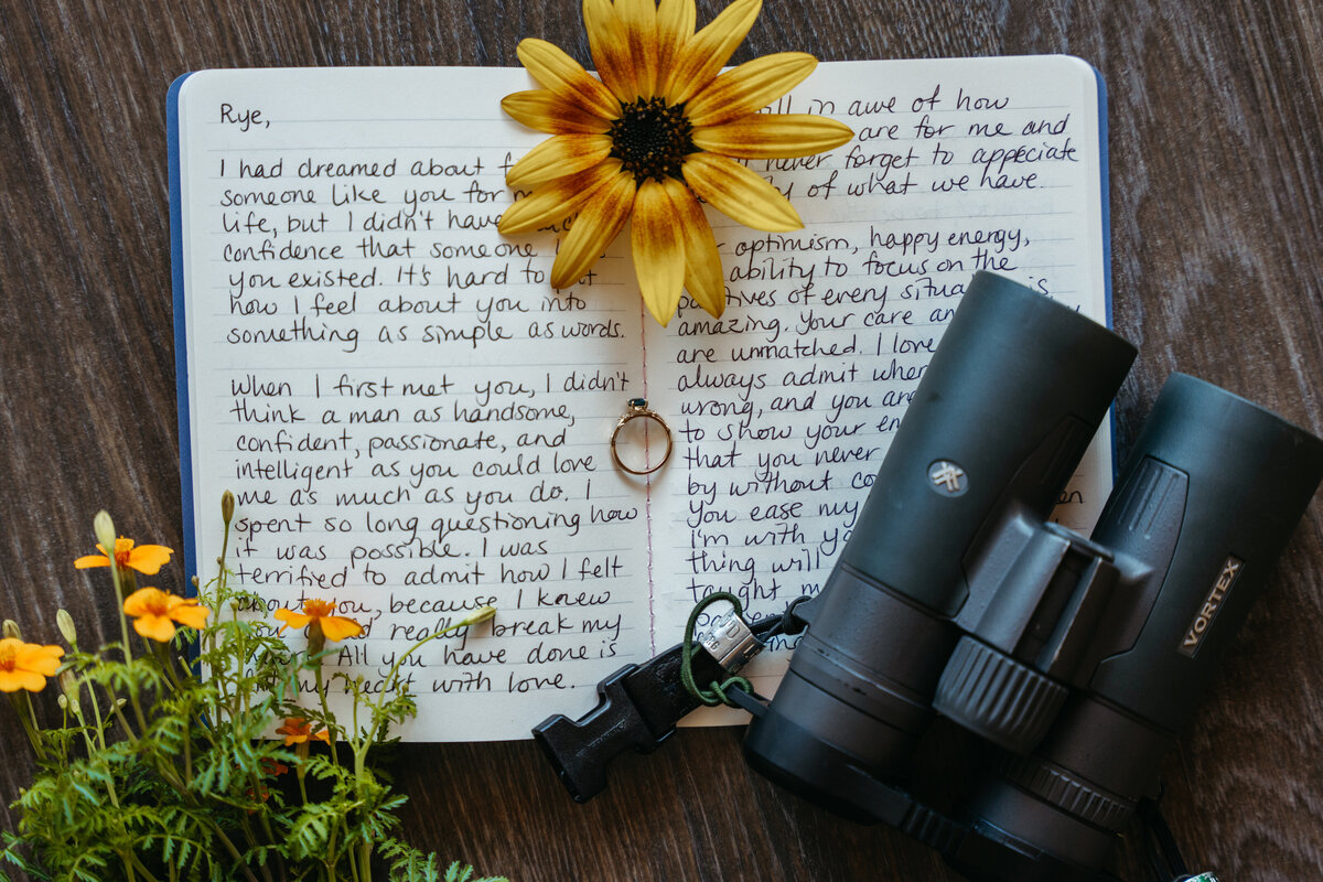 Wedding letter and rings with binoculars on table