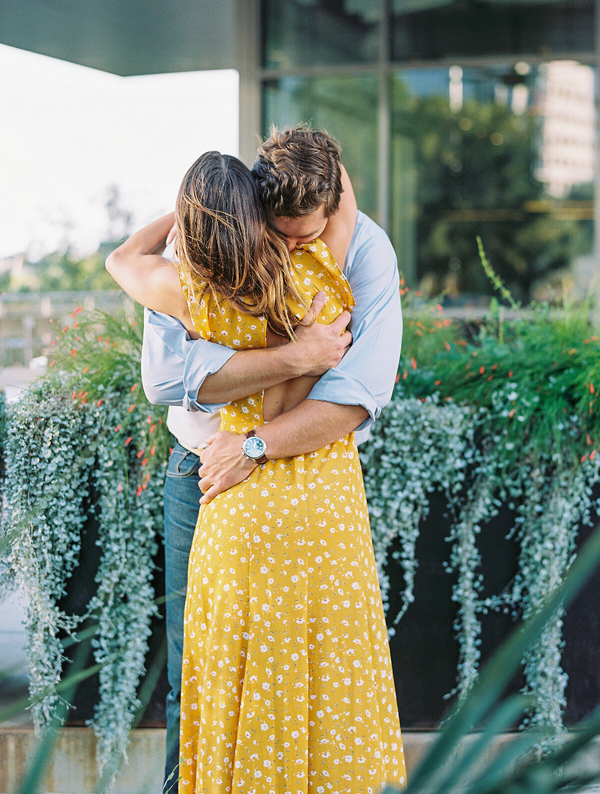 Man hugging woman in a yellow floral dress