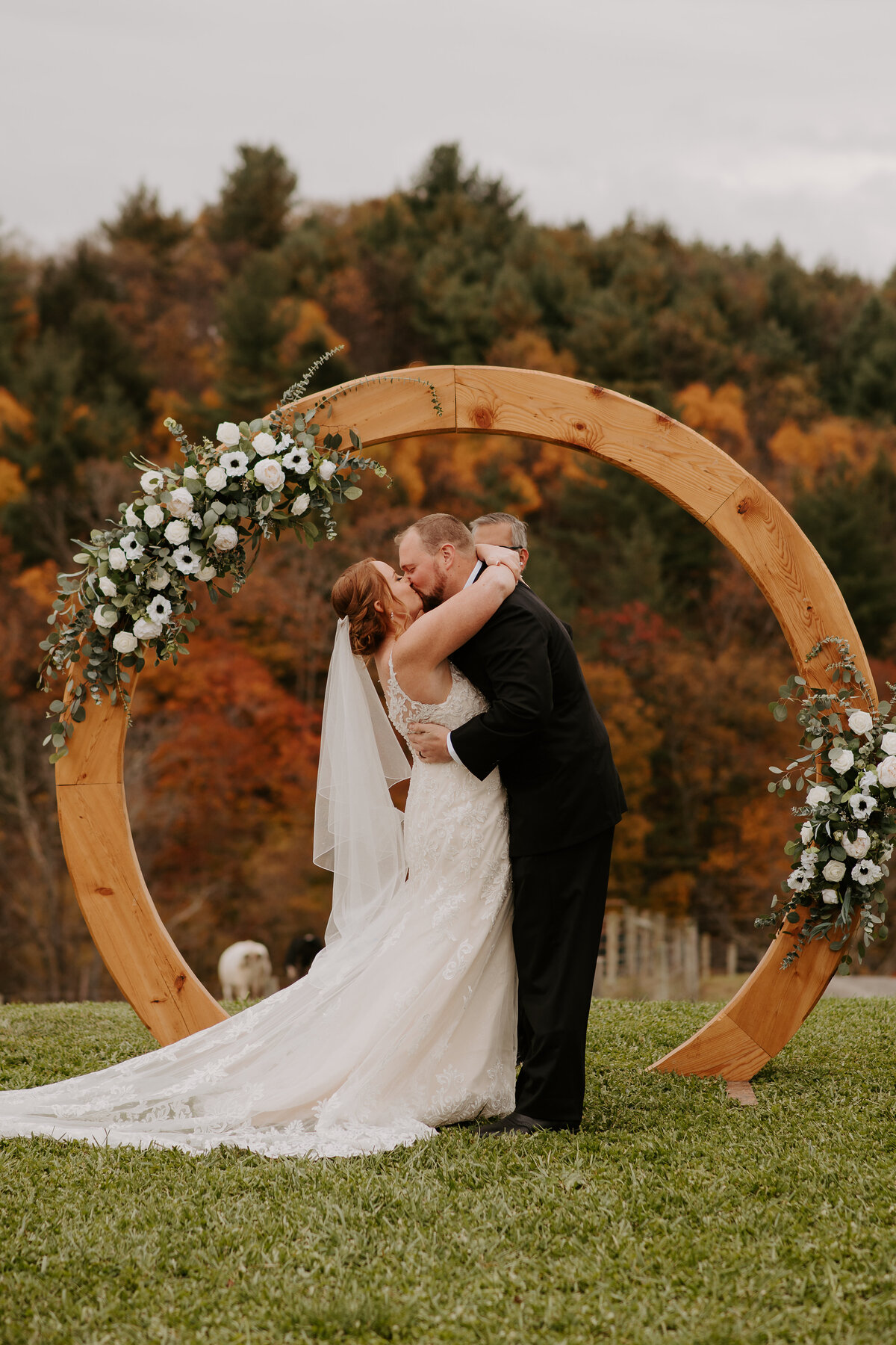 Wooden boho arch with white flowers and eucalyptus at a fall wedding in the mountains of Virginia,
