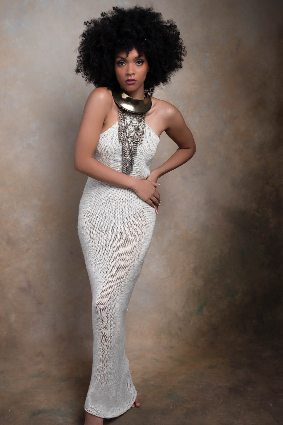 a black woman with short curly hair wearing a white see through  dress