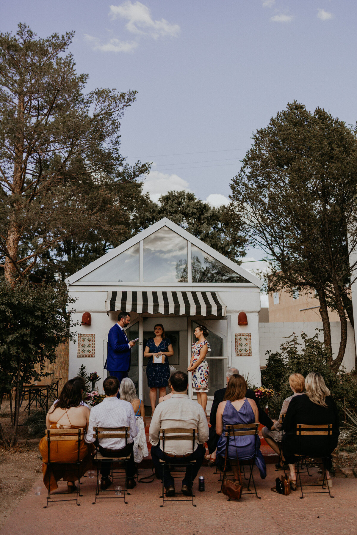 an intimate wedding ceremony set up in front of a greenhouse in  Santa Fe, New Mexico