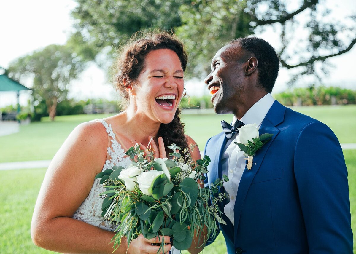 Bride and Groom laughing and smiling  while holding the bouquet