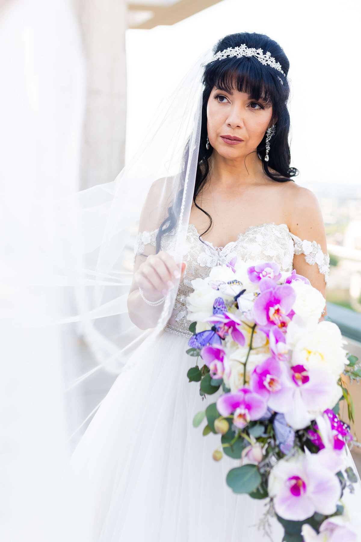 Bride holding bouquet of purple orchids and white florals for wedding at The Aertson hotel, Nashville