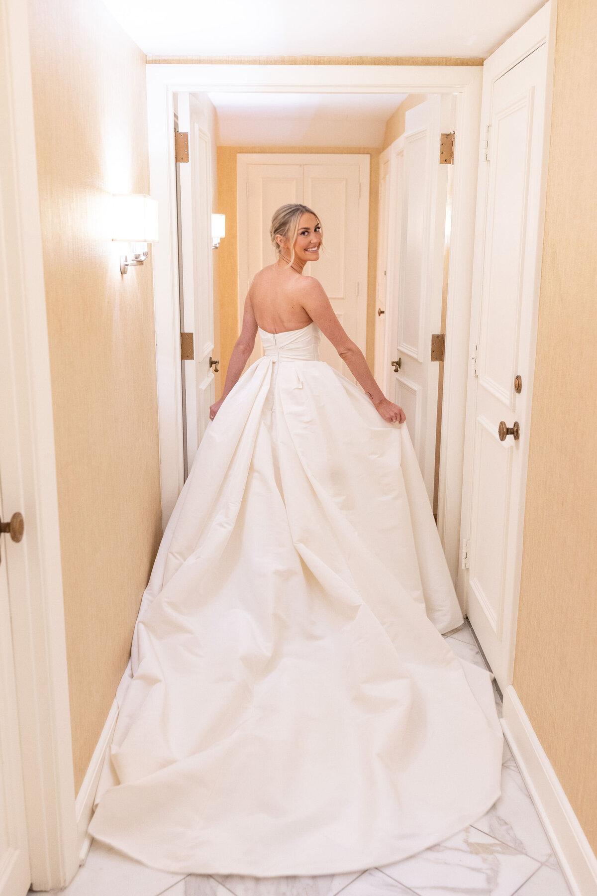 A smiling bride wearing a white wedding dress.