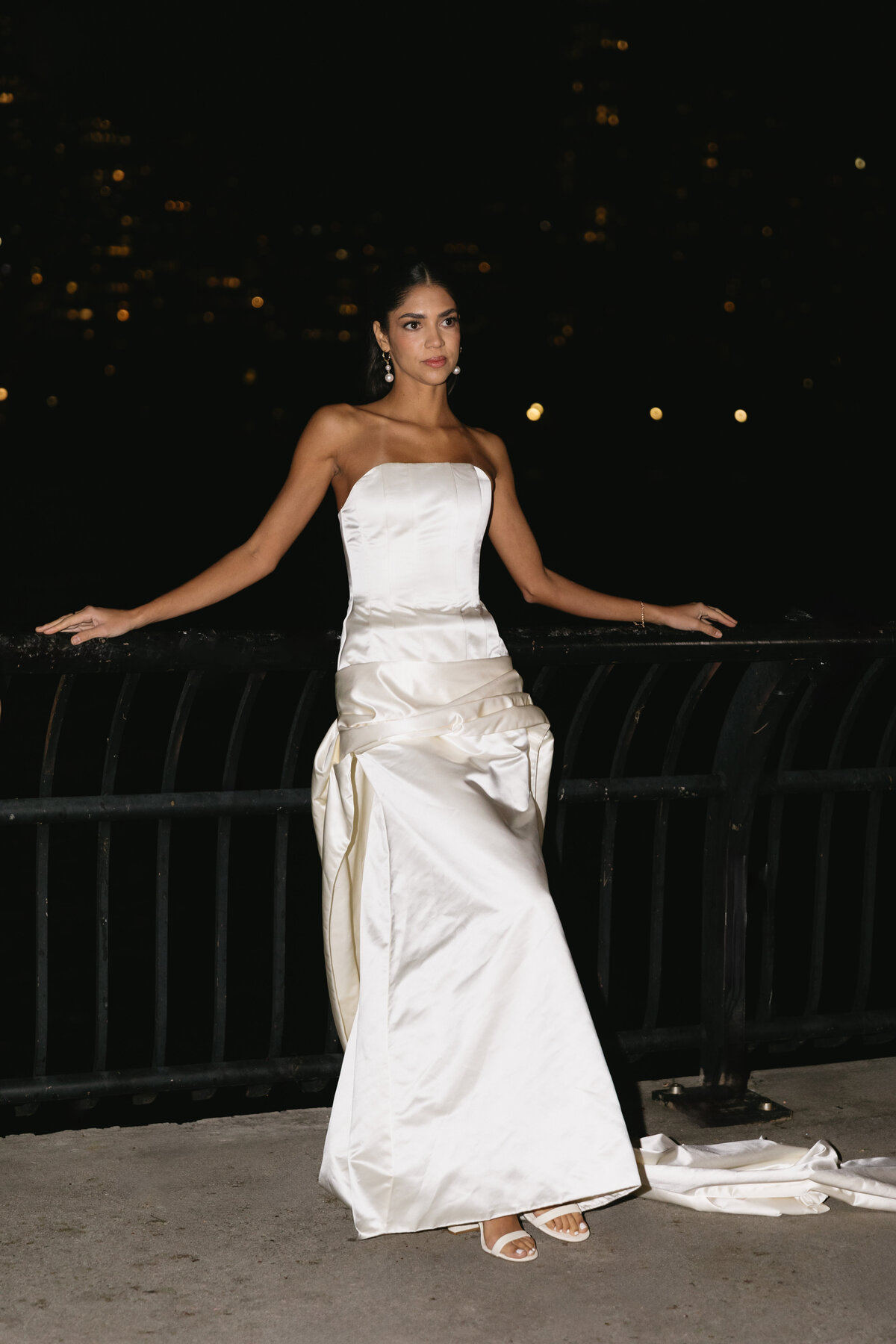 Editorial bridal fashion portrait featuring a modern satin gown at night.