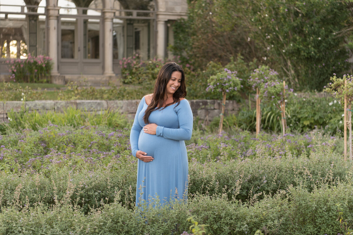 Pregnant mom in garden with mansion