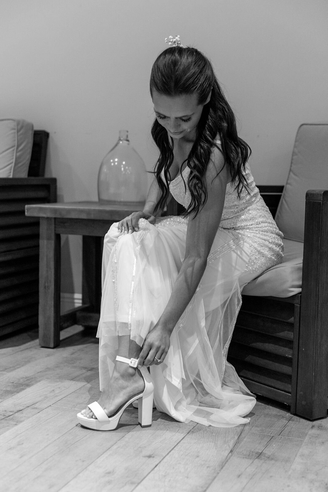 bride putting her wedding shoes on at The Tides Club