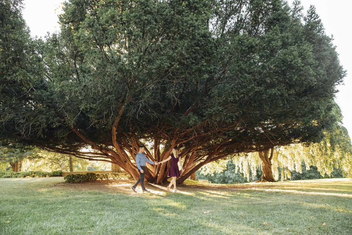 Couple walking at sunset during summer engagement shoot at New Jersey Botanical Garden in Ringwood New Jersey