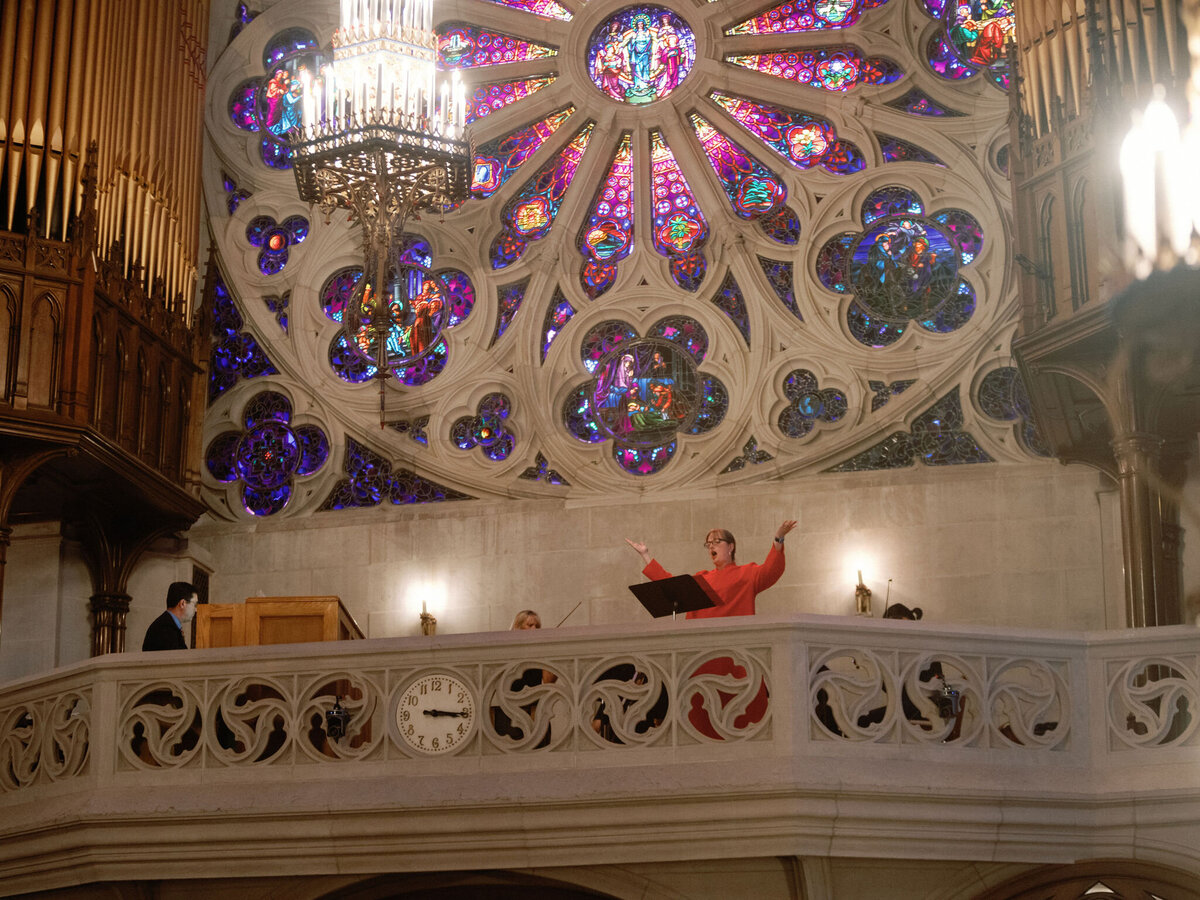 Stunning rose window and chandelier inside the church during the wedding ceremony.