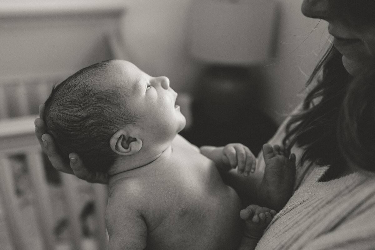 Longmont newborn looking up at mom