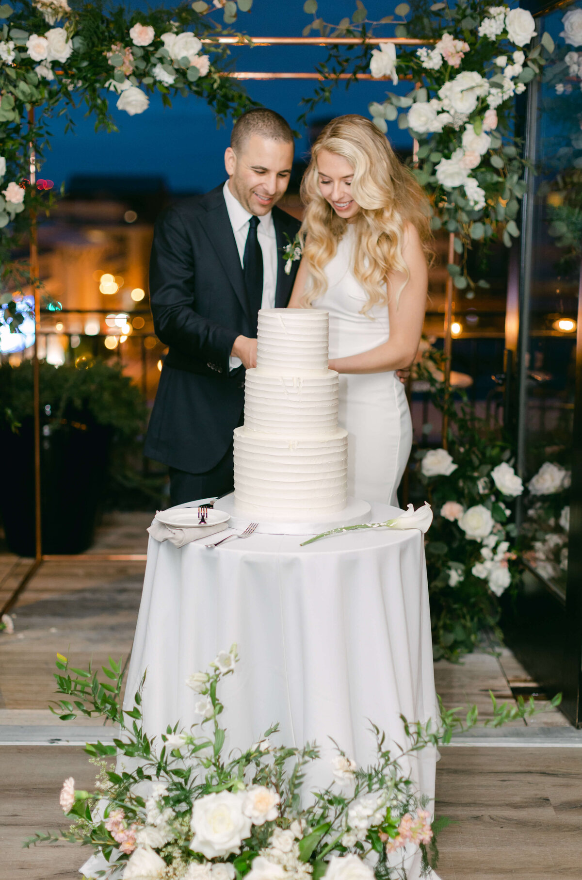 A bride and groom cut their wedding cake.
