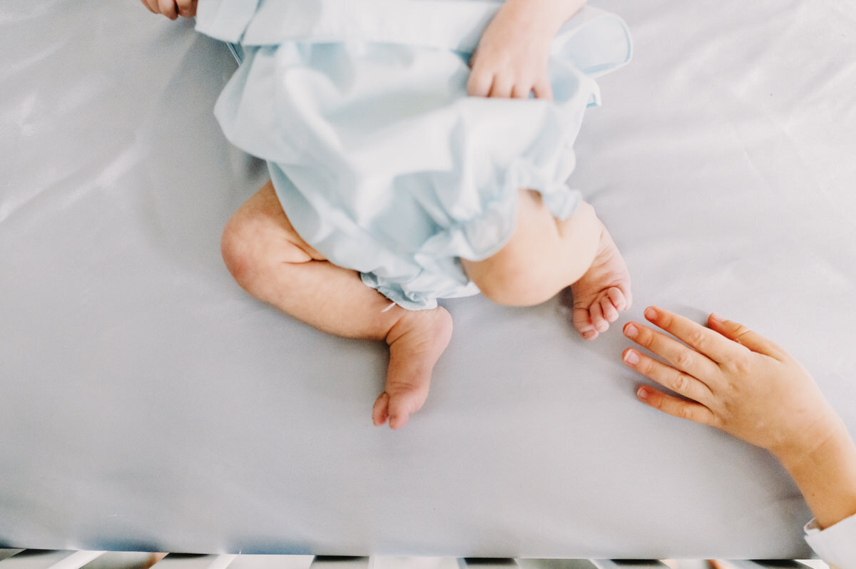 babys feet and big brothers hand  close up