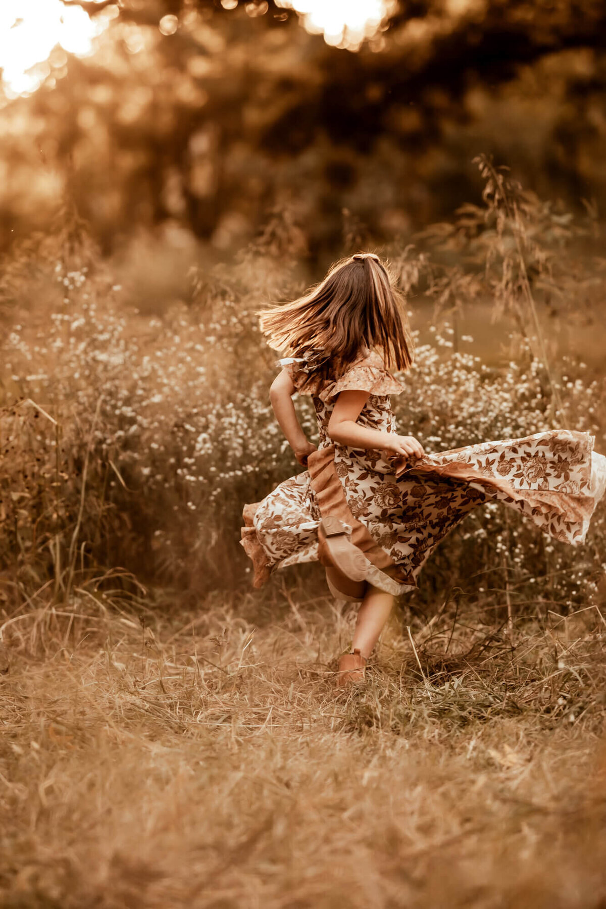 Girl spins in a field with her hair flying in the wind.