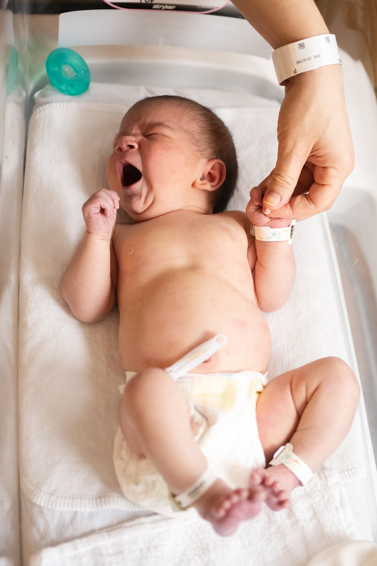 Yawning baby in bassinet