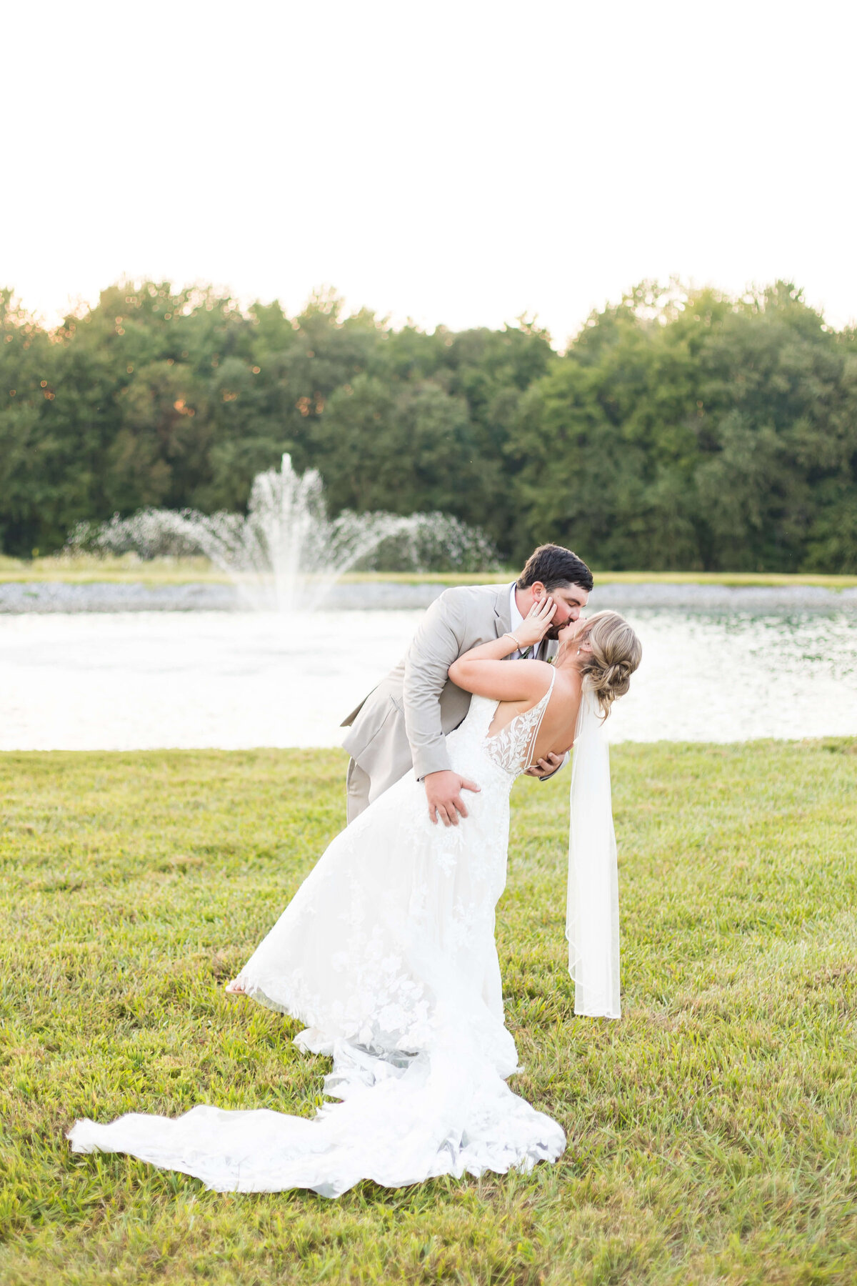 Bride and groom kissing in front of a fountain at  The Barn at White Oaks, Murray, Kentucky