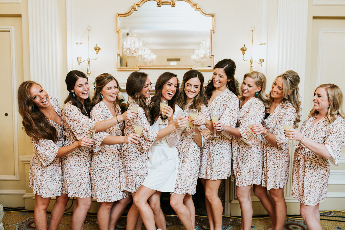 Bride and bridesmaids in robes with mimosas