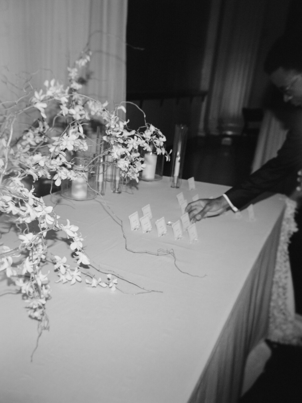 natural, documentary wedding photo of guests reaching for place cards at State Savings Bank