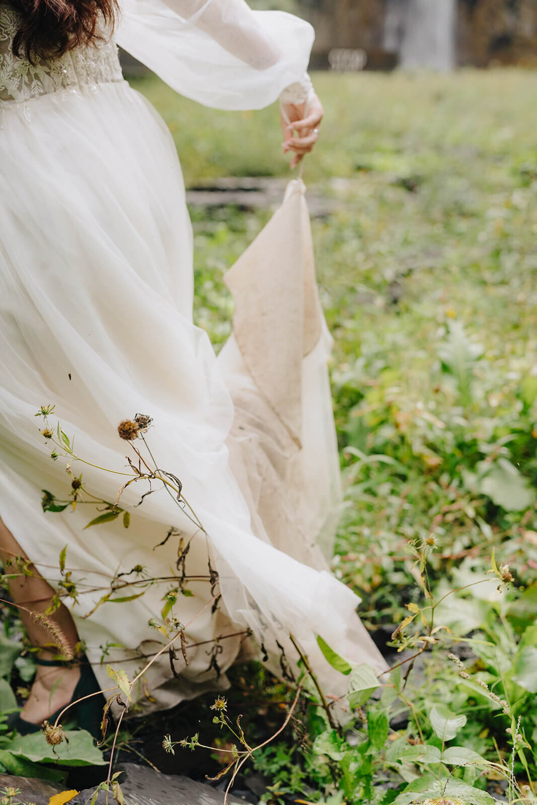 Bride walking along holding dress up